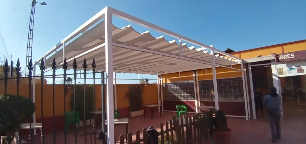 Pérgola con lona de palillería y estructura blanca